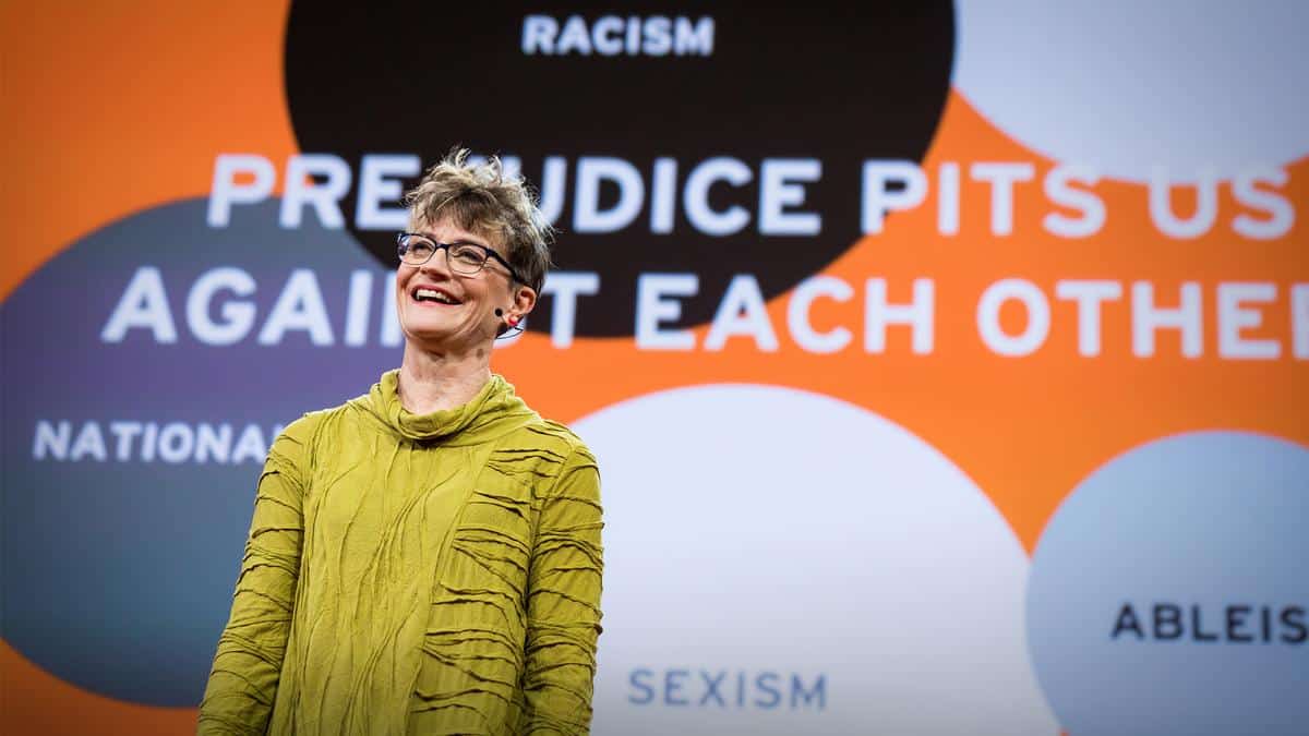 Ashton Applewhite, a light-skinned woman with short hair, gives a talk on the TED stage.
