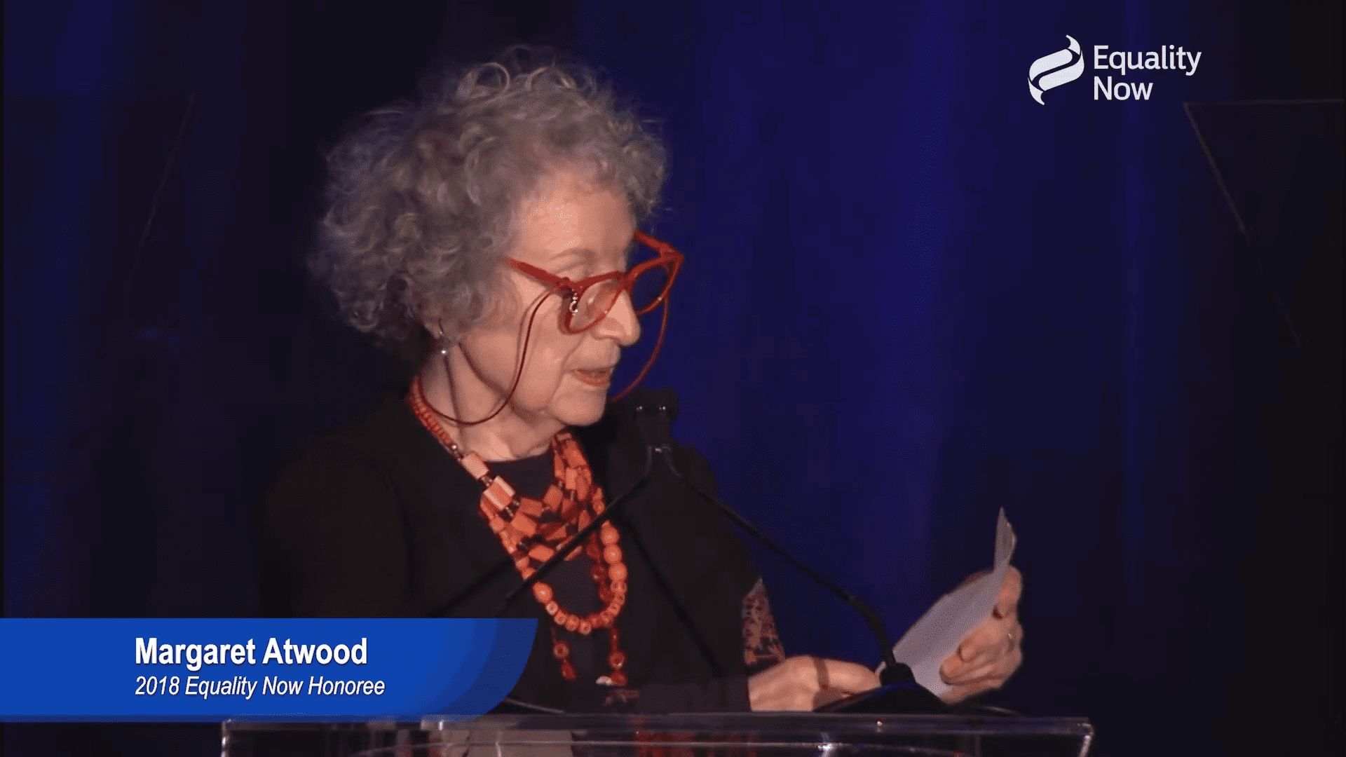 Margaret Atwood, a woman with curly grey hair, at a podium giving a speech