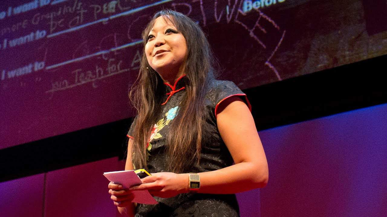 Candy Chang, an Asian woman with dark hair, gives a talk on the TED stage.