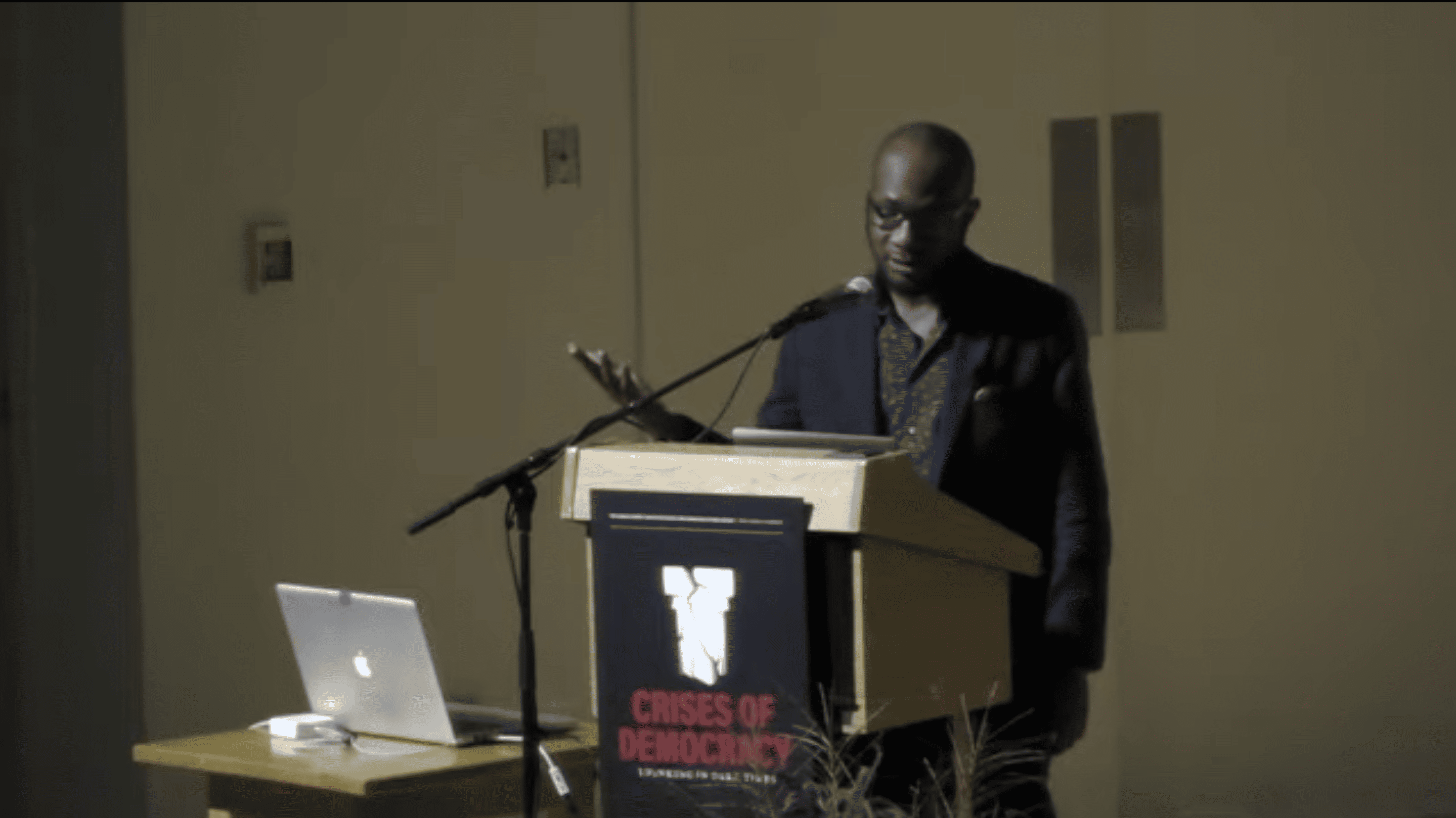 Teju Cole, a dark-skinned man, giving a talk.