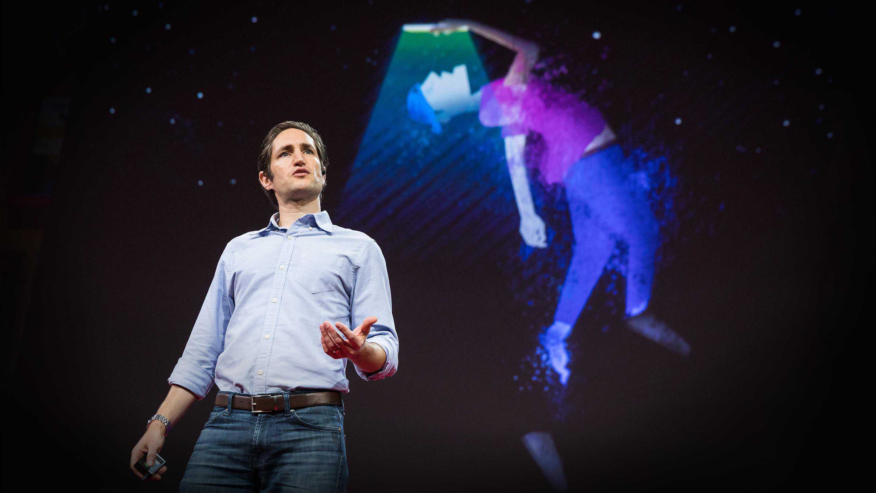 Adam Alter, a light-skinned man with dark hair, gives a talk at TED.