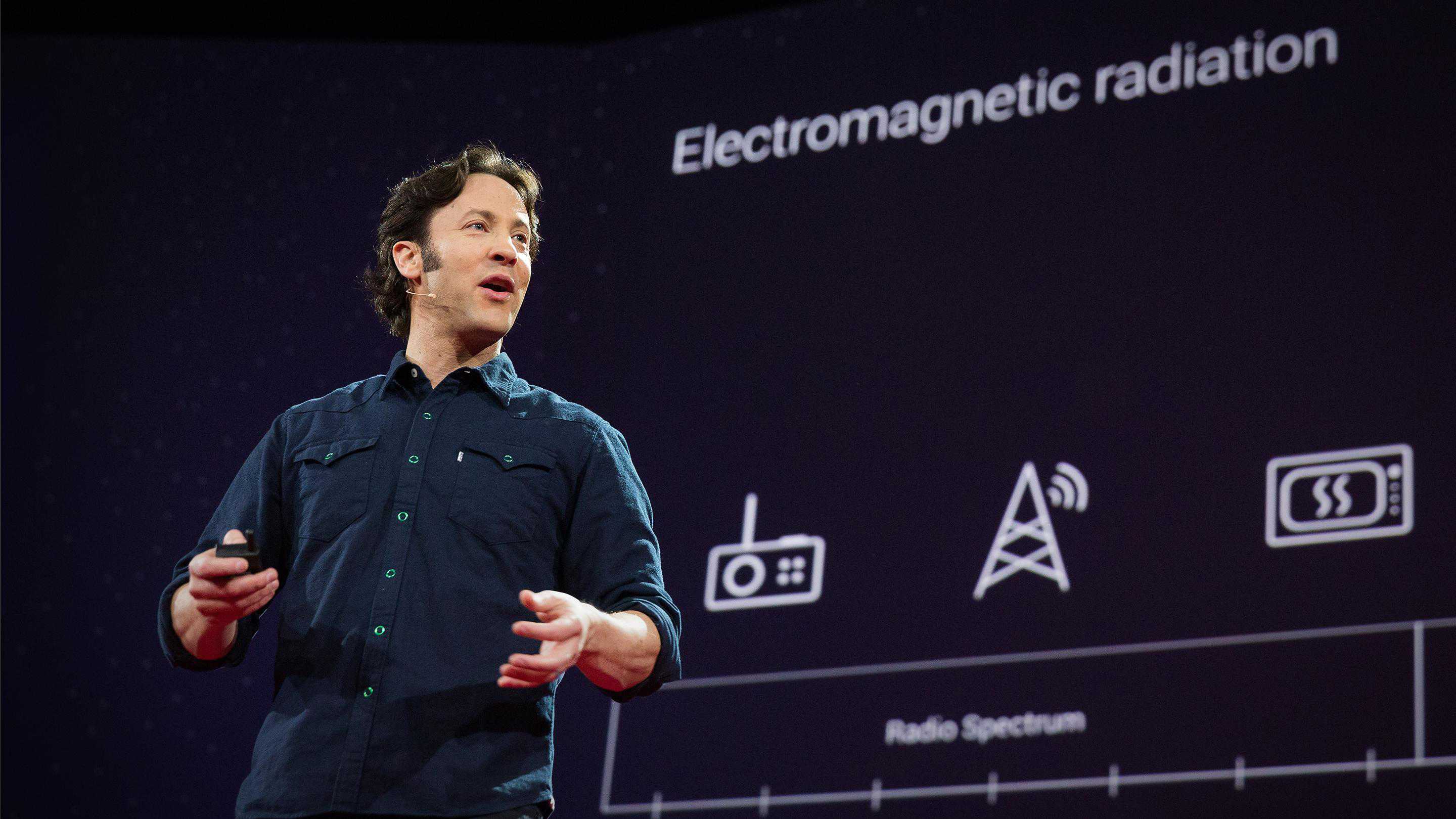 David Eagleman, a light-skinned man with dark hair, gives a talk on the TED stage