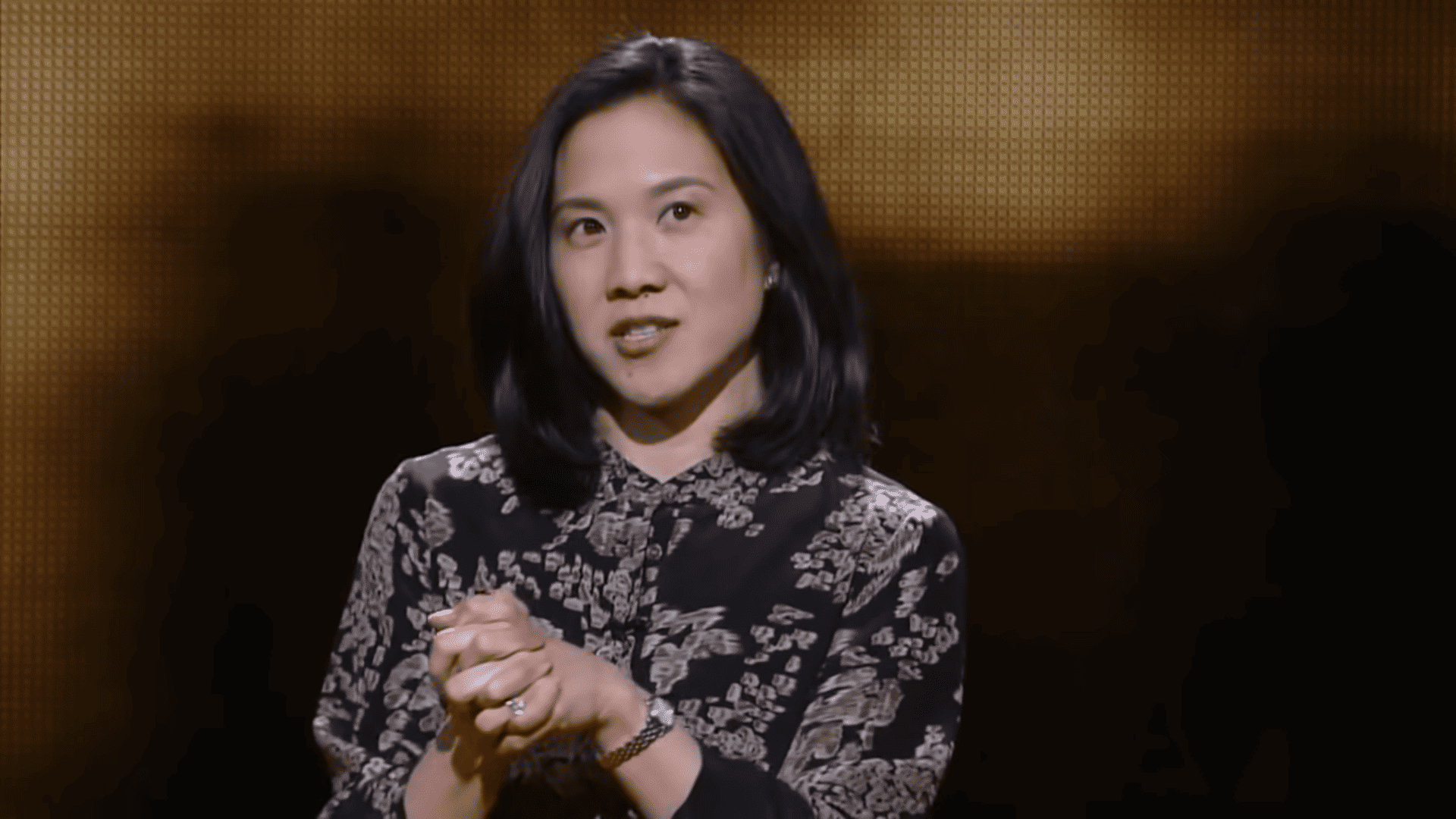 Angela Duckworth, a woman with black hair, on the TED stage giving a talk