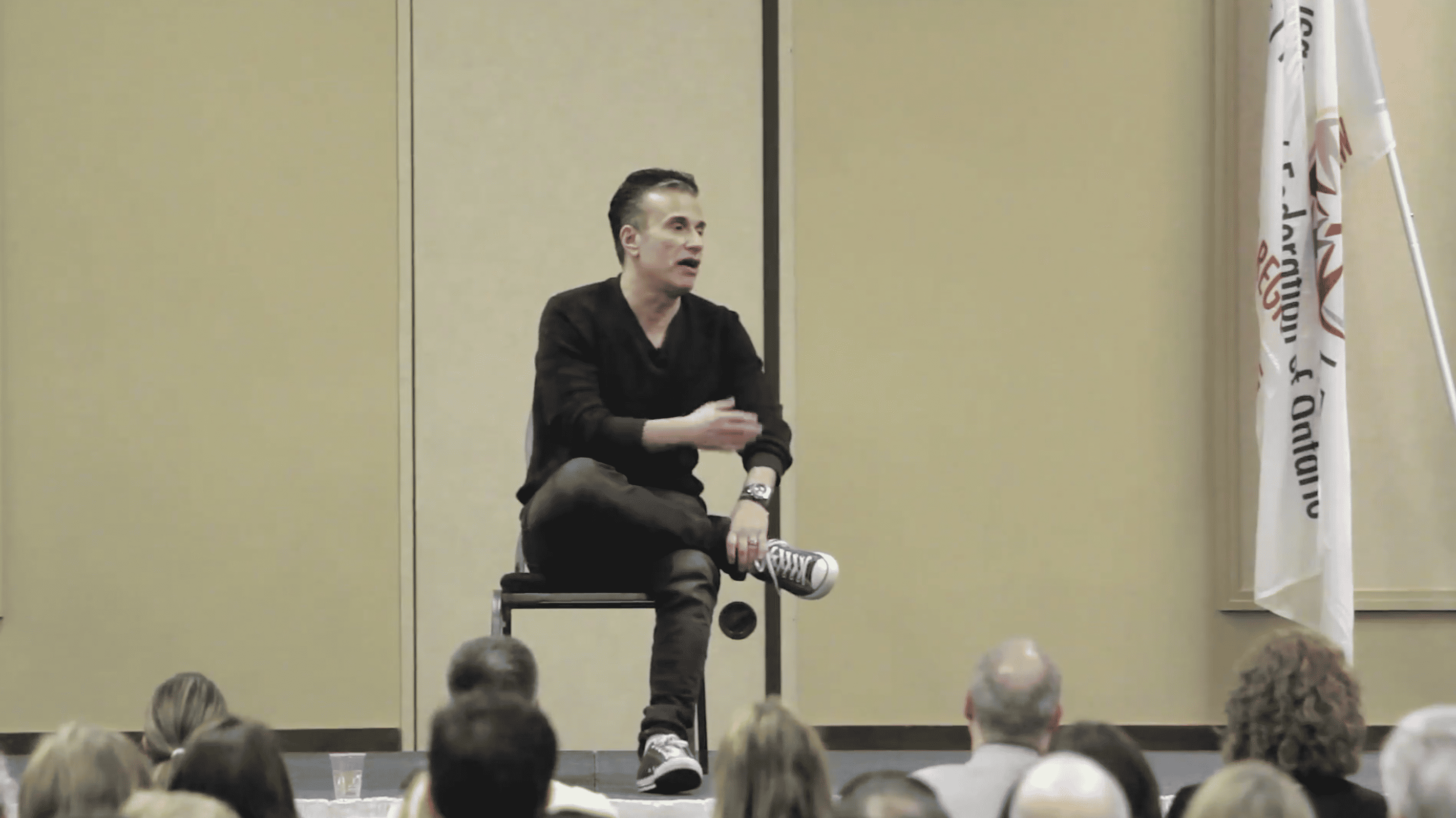 Michael Landsberg, a light-skinned man with dark hair, gives a talk onstage.