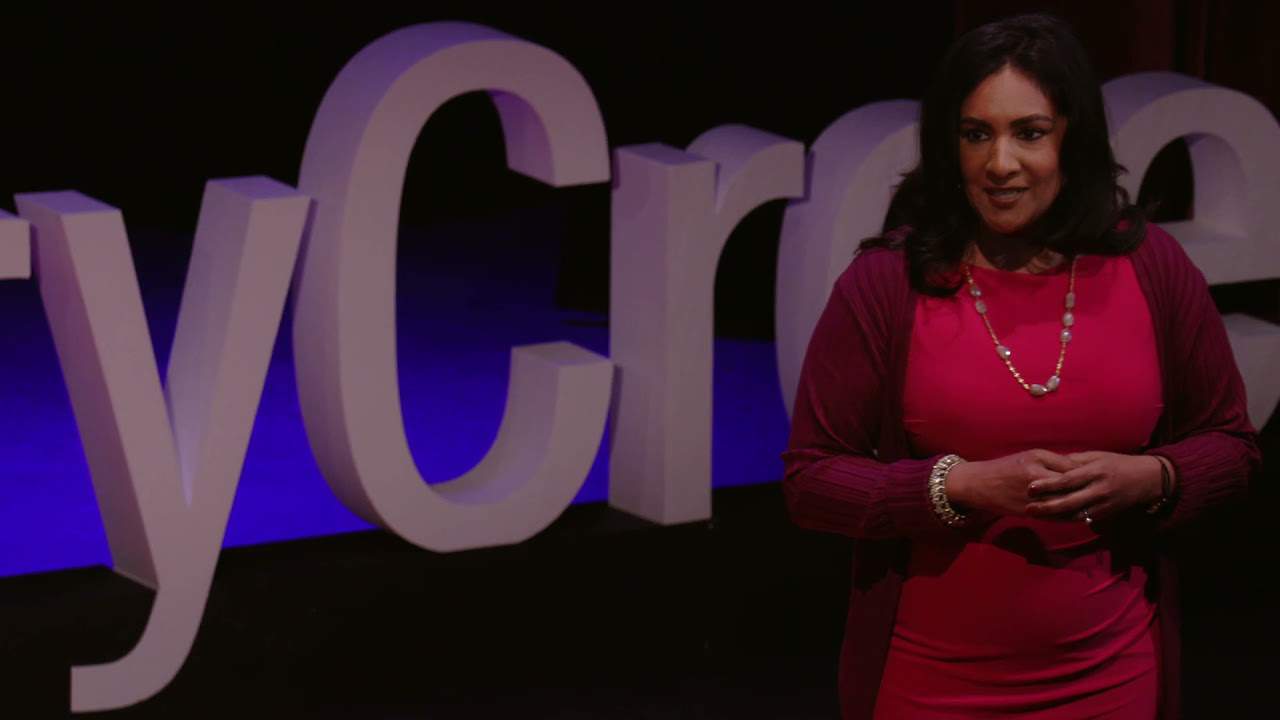 Deepa Purushothaman, an Indian woman with dark hair, gives a talk on a TEDx stage