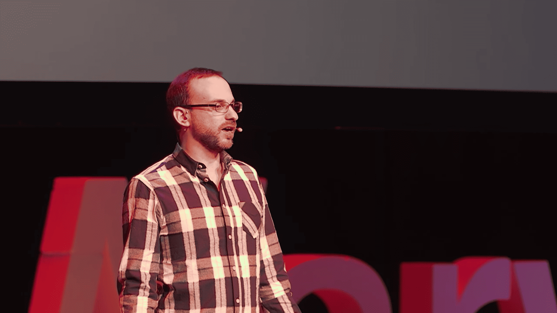 Seth Stephens-Davidowitz, a white man in a checkered shirt, giving a talk on a stage.